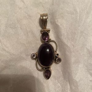 Beautiful purple pendant, adorned by some simulated stones. Shines and bright